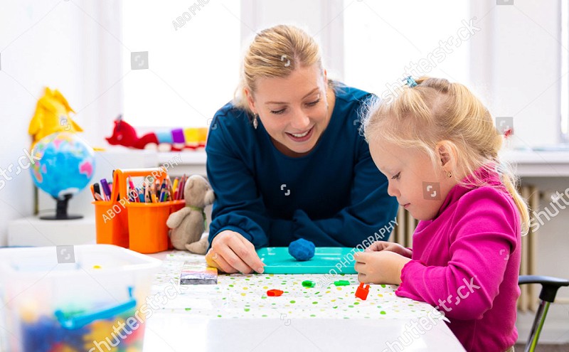 Stock photo toddler girl in child occupational therapy session doing sensory playful exercises